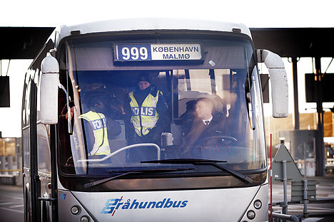 Police officers check a bus that arrived by ferry from Denmark. Photo: Nils Meilvang/Scanpix