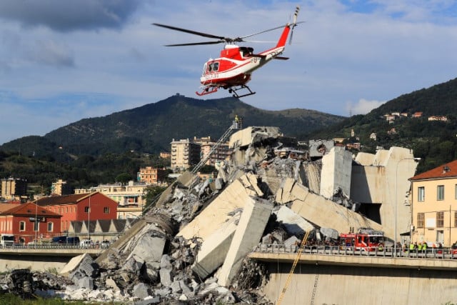 A helicopter flies among the wreckage of the collapsed bridge. Photo: Valery Hache / AFP