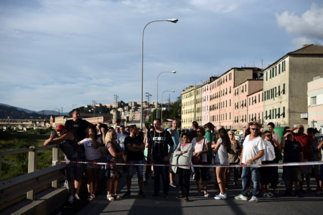 A cordon is set up as people stand looking at the Morandi motorway bridge. Piero Cruciatti / AFP