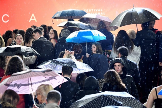 Guest arrive under the rain for the screening of the film 