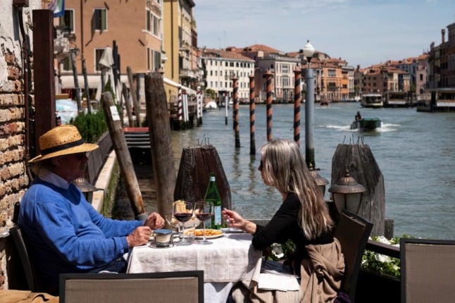 A couple eat at a restaurant in Venice.