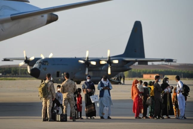 A group of Afghan nationals stand on the tarmac after disembarking from the last Spanish evacuation flight at the Torrejon de Ardoz air base near Madrid in August. Photo: PIERRE-PHILIPPE MARCOU / AFP)