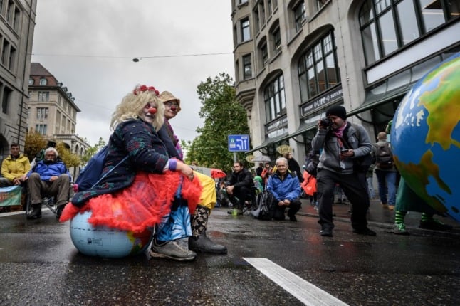 Demonstrators affiliated with global environmental movement Extinction Rebellion (XR) stage a protest in the center of the city of Zurich