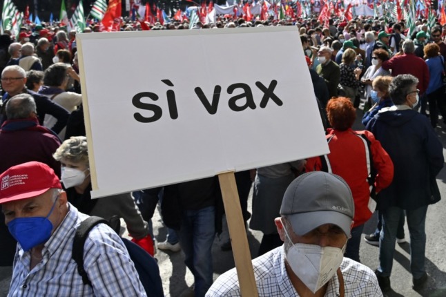 A man holds a placard reading "yes to the vaccine" during an anti-fascist rally at Piazza San Giovanni in Rome