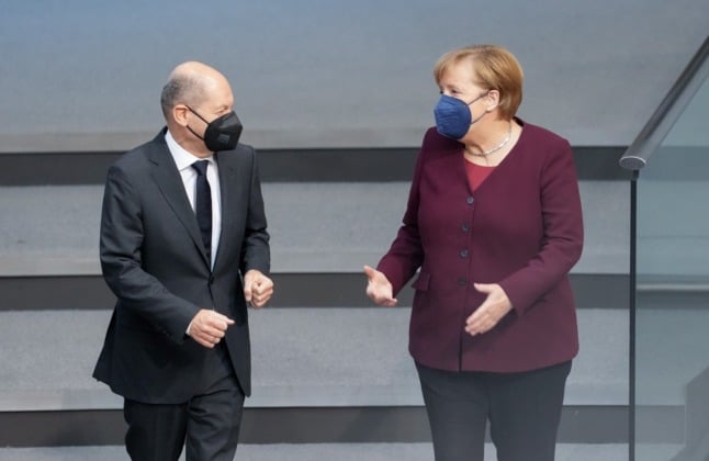 SPD's chancellor candidate Olaf Scholz speaking to outgoing chancellor Angela Merkel in the Bundestag on Thursday. 