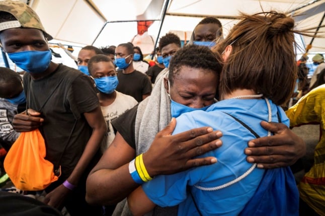 A young migrant hugs a doctor onboard the Sea-Watch 4 rescue ship off the coast of Sicily on September 01, 2020. 
