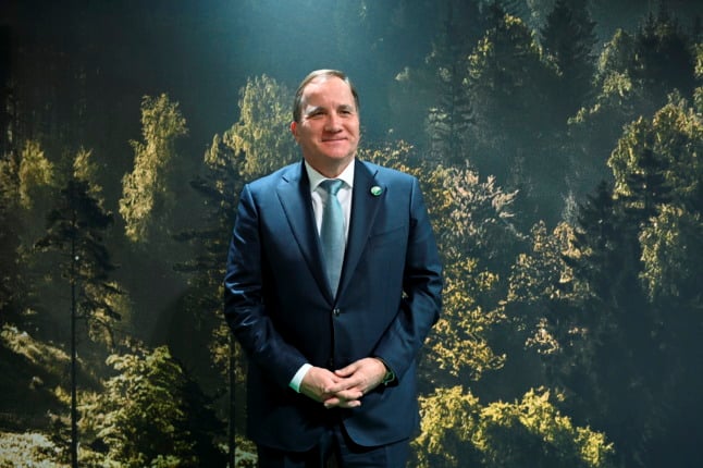 sweden's outgoing prime minister in front of a backdrop of a forest