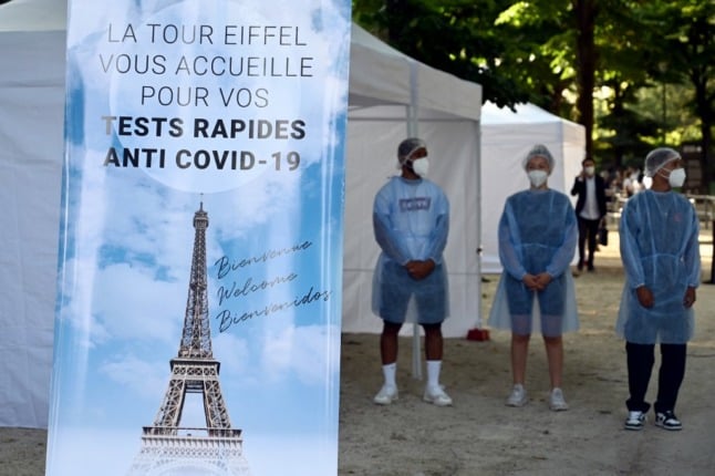 Health workers stands near a Covid-19 rapid antigen testing area near The Eiffel Tower in Paris.