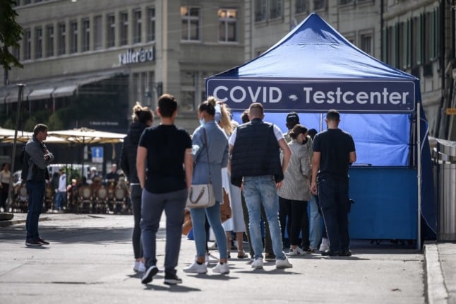 People queue at a Covid test centre in a street in Bern, Switzerland