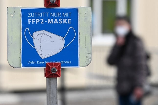 A sign informs people to cover mouth and nose with an FFP2 mask