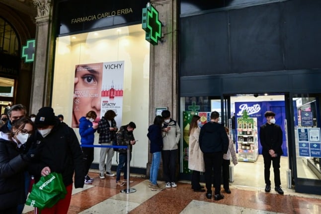 People line up outside a pharmacy to be tested for coronavirus in central Milan. 