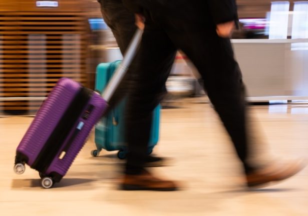 A person takes luggage through Berlin airport. 