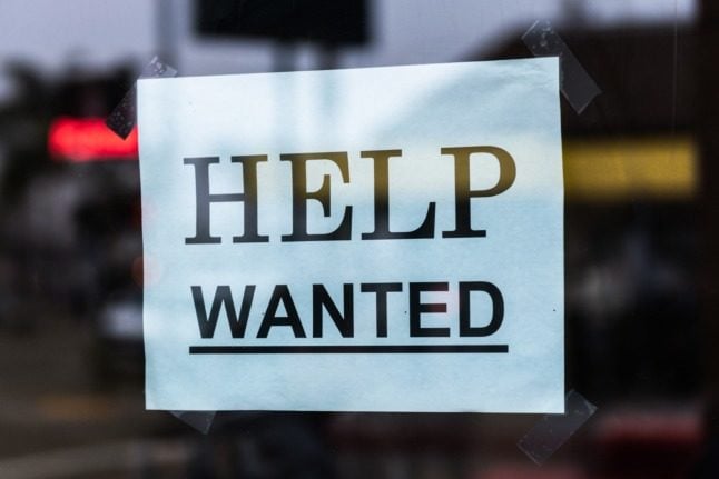 A help wanted sign seen in a window