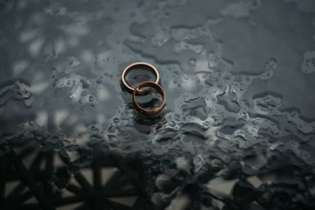 Two wedding rings on a wet table